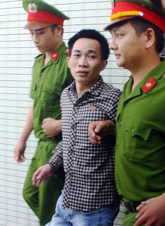 Bị cáo được cảnh sát hỗ trợ tư pháp áp giải ra xe thùng. Ảnh: Điền Quang.