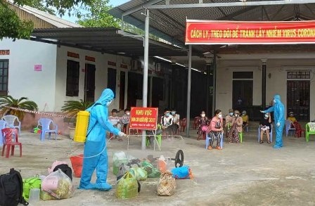 Nguoi phu nu tu nguyen cho trung dung nha lam khu cach ly hinh anh