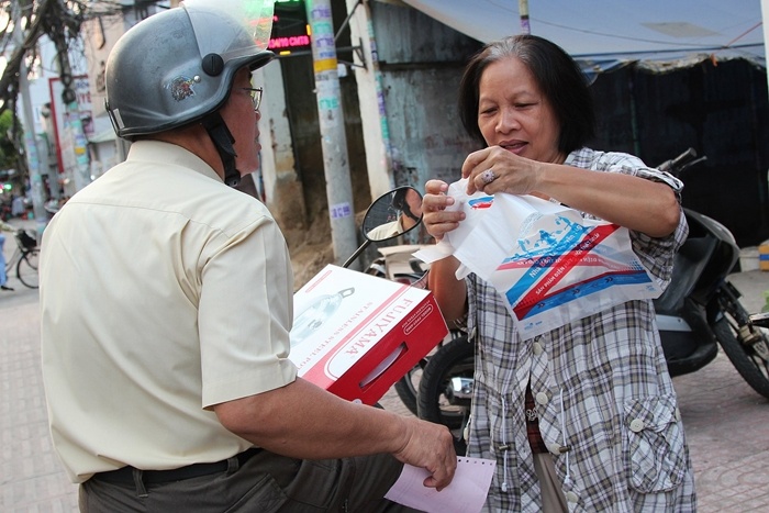 Một khách hàng vui vẻ khoe món hàng khuyến mãi vừa mua được với người thân.