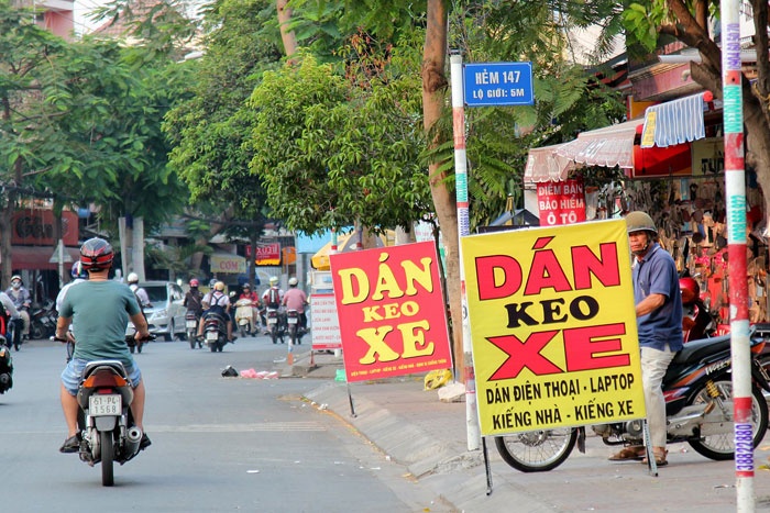 Một bảng quảng cáo đang che mất tầm nhìn của một người đi đường từ trong hẻm ra.