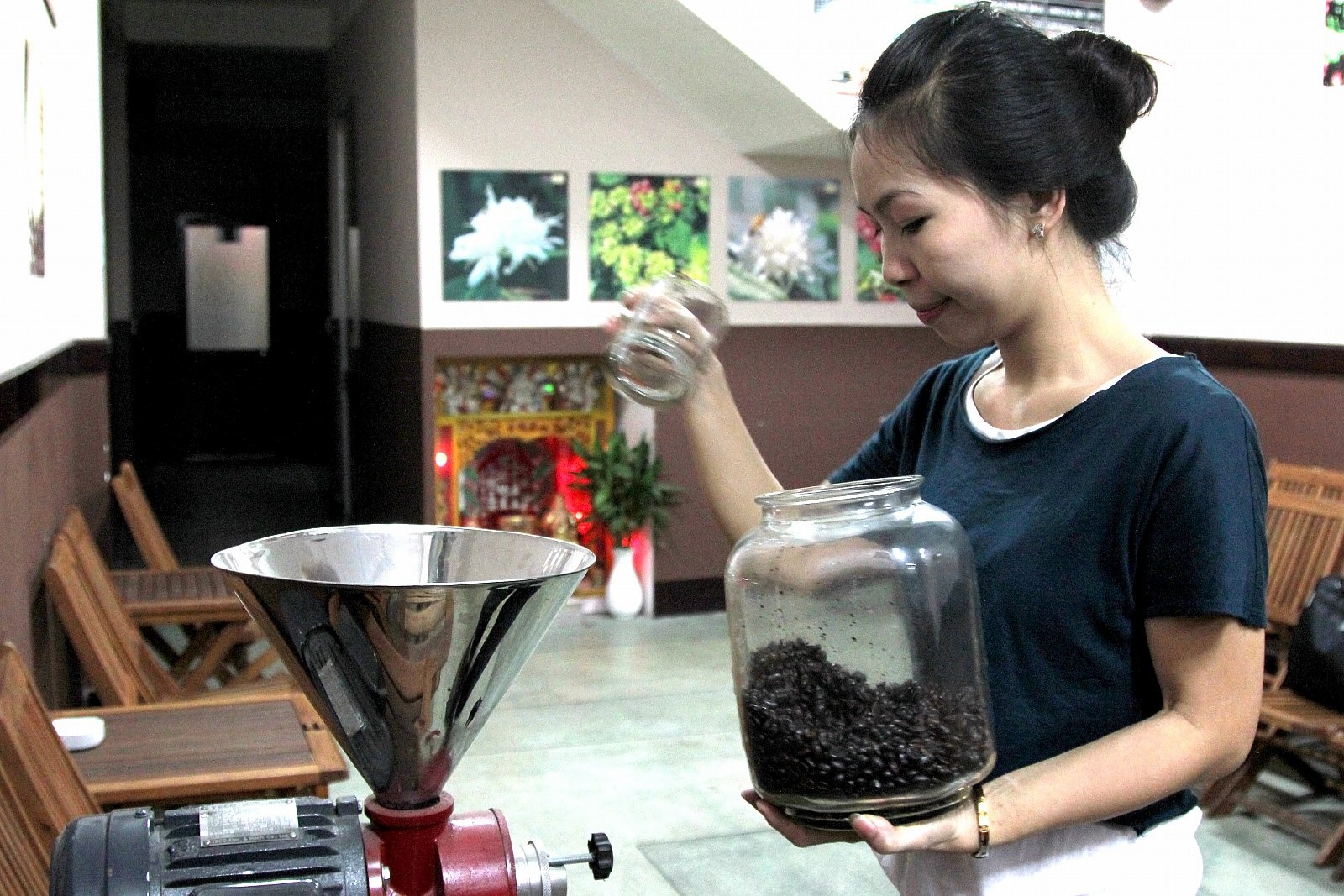 Cà phê hạt đang được cho vào máy để xay.