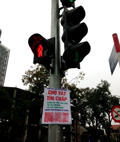 Số lượng quảng cáo cho vay tín chấp đặt tại các cột đèn, biển báo giao thông tại Hà Nội ngày càng tăng nhằm thu hút sự chú ý của người tham gia giao thông khi chờ đèn đỏ