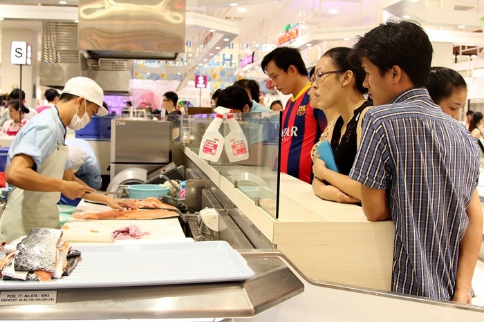 Nhiều khách hàng tò mò vây quanh khu chế biến để xem quá trình làm sushi.