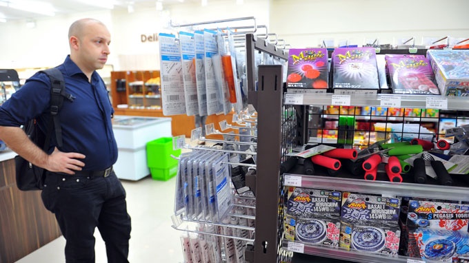 Khách nước ngoài chọn mua hàng tại một cửa hàng tiện lợi trên đường Lê Thánh Tôn (quận 1, TP.HCM).