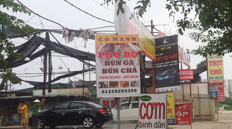 Cả tuyến đường dày đặc các biển hiệu kinh doanh từ cơm phở, rửa xe cho đến nội thất ô tô.