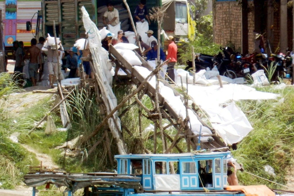 Tại cửa khẩu Campuchia giáp với cửa khẩu Khánh Bình, ì ầm hoạt động chuyển đường xuống ghe bằng băng chuyền  .