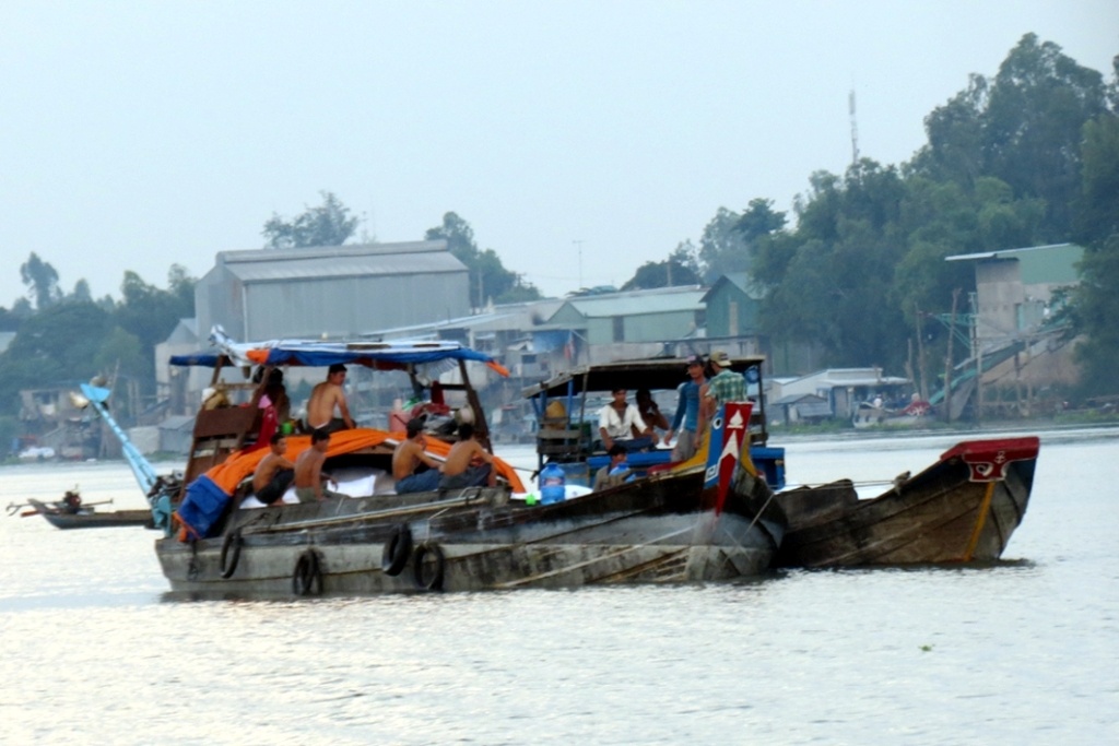Chiếc ghe chài chở khoảng 100 tấn đường khẳm đè đậu sát bờ sông Hậu thuộc xứ sở Chùa Tháp đang hoạt động sang đường cho các ghe Việt Nam để vào địa phận An Giang.