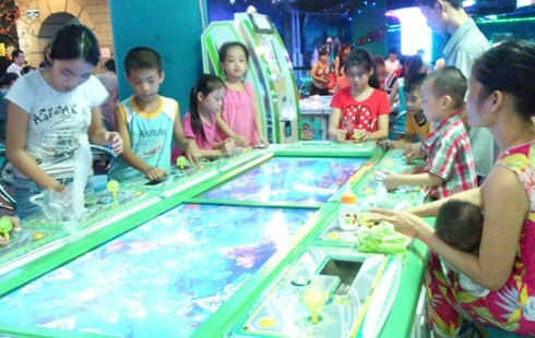 Một phụ nữ bế con nhỏ chơi game liên tục vài tiếng đồng hồ.