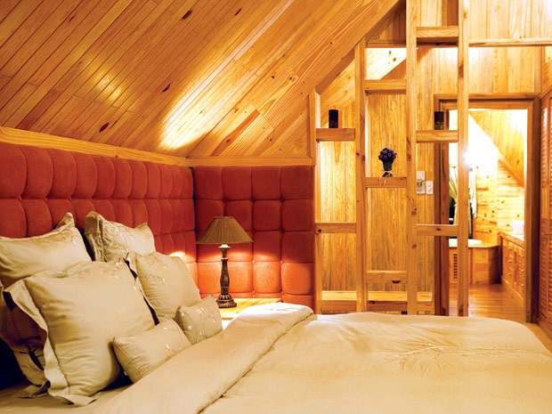 Phòng ngủ được ốp tường và trần bằng gỗ quý.