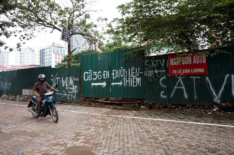 Rao vặt, chỉ đường trên một đoạn tường bao một khu đất dự án trên đường Lê Văn Lương.