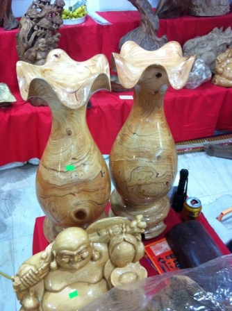 Cặp lộc bình được tiện từ loài thông núi - Hà Giang. Ngoài những sản phẫm lũa ngọc am được trưng bày, khách đến Triển lãm Nông nghiệp cũng không khỏi trầm trồ trước bộ điêu khắc khá lớn có tên: Cha Rồng – Mẹ Tiên sinh trăm trưng.  Đây là tác phẩm gỗ mỹ nghệ của một cơ sở chế tác ở Phú Thọ. Người thực hiện tác phẩm này đã thể hiện sự tài hoa trong các đường đục trạm, phối cảnh khá cân đối, hài hòa… để tạc dựng hình ảnh Rồng - Phượng tinh vi, đẹp mắt.  Một tác phẩm trạm trổ ông Thần tài khổng lồ có chiều cao chừng 1.60m; bề rộng chừng 50cm nguyên khối từ gỗ Thủy tùng – một loài cây được cho rằng có niên đại cùng thời với khủng long, trên thế giới chỉ còn số lượng cây đếm trên đầu ngón tay, trong đó Việt Nam còn một quần thể ở Ea H’leo (tỉnh Đắc Lắc).  Ngoài sự thán phục về đường nét chạm trổ, nguồn gốc gỗ quý hiếm, người xem cũng không khỏi kinh hoàng khi mức giá được chủ nhân đưa ra gần 200 triệu đồng; mức giá chốt “bán nhanh vì đóng cửa triển lãm” là… 168 triệu đồng cho bức tượng Thần tài gỗ Thủy tùng khổng lồ.