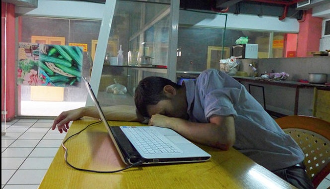 Một tiểu thương ngủ gục tại quầy hàng bán trái cây trong chợ Cửa Nam, Hà Nội.