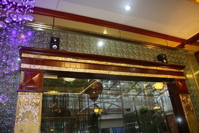 Cửa ra vào phòng khách của căn biệt thự sáng loáng với các lớp vàng trang trí xung quanh.