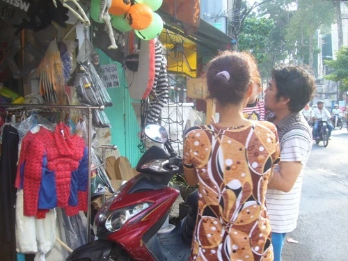 Nhiều bạn trẻ thích thú với mặt nạ kinh dị  Tại shop Hanah (Cách Mạng Tháng 8, Q.10) người bán cho khách xem sản phẩm mới, độc đáo là những chiếc tô mủ với thiết kế đầu lâu đính kèm một bên. Khi người lớn bỏ kẹo, bánh vào tô, trẻ nhỏ thò tay vào lấy, đầu lâu sẽ lao ra phía trước “dọa” người, giá 140.000-160.000đồng/sản phẩm.  Các cửa hàng đã bắt đầu đông khách. Đối tượng khách hàng chính là các bạn học sinh, sinh viên. Ngoài ra có không ít phụ huynh cũng dẫn các bé đến chọn mua trang phục hóa trang. Anh Hoàng, bán đồ hóa trang ở Nguyễn Thị Minh Khai (Q.3) cho biết: “Cả tuần nay cũng có nhiều người đến tìm mua mặt nạ, áo choàng cho con. Mặt hàng nào kinh dị quá, phụ huynh cũng không thích- trong khi trẻ con thích những gì ma quái, rùng rợn”.