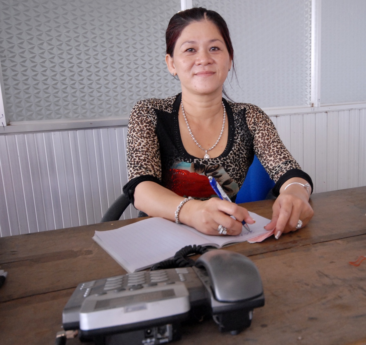 Chị Cúc đang ngồi bàn điều hành mua bán trái cây qua điện thoại.  Ảnh: Ngọc Trinh