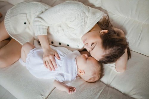 Tre con ngu o sofa hoac cung giuong voi nguoi lon de dot tu hinh anh