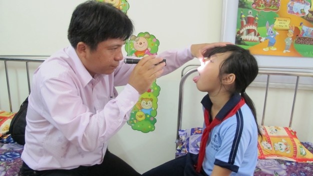 Bác sĩ Bệnh viện Nhi Đồng 1 đang khám bệnh cho học sinh trường tiểu học Nguyễn Khuyến.