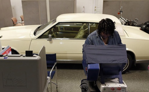 Người phụ nữ đang tập trung lựa chọn để bỏ phiếu tại một cơ sở bán xe ô tô.