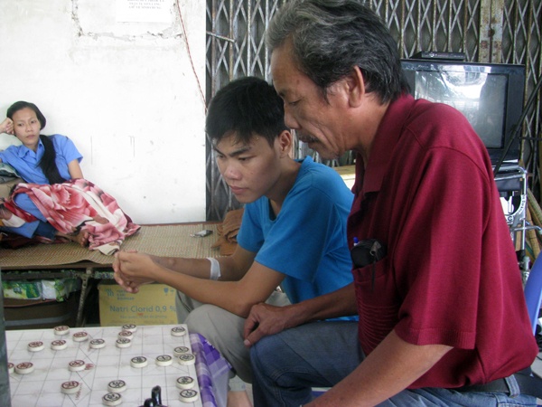 Xót xa nhất là những người trẻ ở xóm, họ bỏ những giấc mơ về một tương lai tươi sáng để chôn chặt cuộc sống  của mình nơi đây. Cậu sinh viên Dương Quốc Bỉ tìm lại niềm vui với những người bệnh xóm chạy thận. Tranh thủ  giờ nghỉ, cậu lại xem cờ tướng giải trí. “Hết năm nhất trường Cao đẳng giao thông vận tải 3 TP.HCM, em phát hiện  mình bị bệnh thận. Lúc mới bệnh em buồn lắm, hoảng sợ và thậm chí nghĩ quẩn muốn chết cho xong. Em tắt máy  1 tuần, trốn đi không muốn ai tìm thấy. Bạn bè, gia đình tìm em về và đưa em đi chữa bệnh. Ban đầu chữa trong  Sài Gòn, chi phí tốn kém nên em nói ba mẹ đưa về quê. Vào đây được gần 2 năm, em nhỏ nhất nên mọi người  cũng quan tâm, an ủi em, nhờ đó em đỡ buồn”, Bỉ chia sẻ. Gia đình làm nông, có 3 anh chị em, Bỉ là con thứ.  Bỉ cho biết từ ngày vào xóm chạy thận, chỉ ngày tết mới về nhà một bữa. Mọi sinh hoạt em đều tự lo lắng, chi phí  chữa chạy hết 1,2 triệu đồng/tháng.