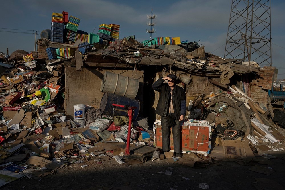 Người đàn ông đang đứng đợi cân hàng hóa thu thập được trước khi đem bán.