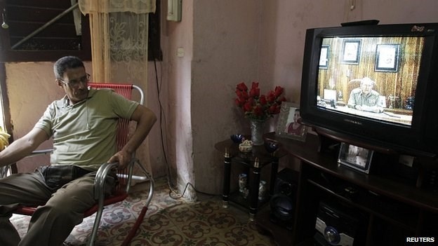 Một người dân đang nghe Chủ tịch Paul Castro phát biểu trên truyền hình về việc Cuba - Mỹ bình thường hóa quan hệ..