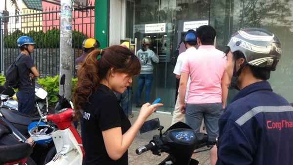 Công nhân chờ rút tiền từ các máy ATM trong Khu công nghiệp Tân Bình, chiều 5/2.