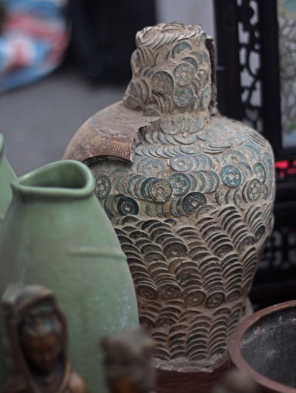 Chum tiền bằng đấy nung bị vỡ lộ hàng nghìn đồng tiền xếp chồng lên nhau.