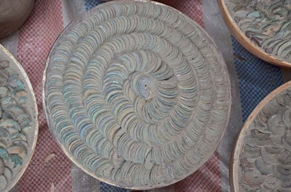 Những chum tiền phủ bụi, dính đầy đất, được xếp thành hình xoắn ốc.