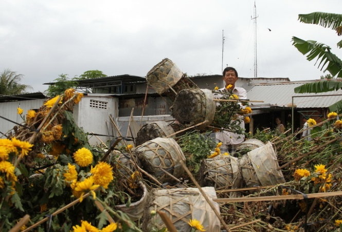 Ông Huỳnh Thế Nguyên thu dọn hơn 1.000 giỏ hoa tồn đọng.
