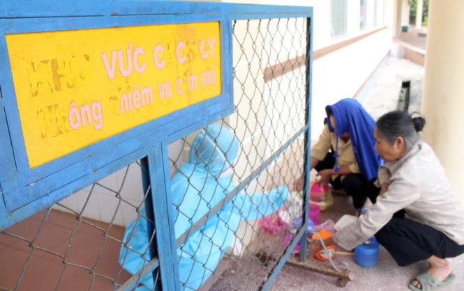 Các phụ huynh  phải nhờ nhân viên mặc đồ bảo hộ đưa cơm trưa vào phòng cách ly.