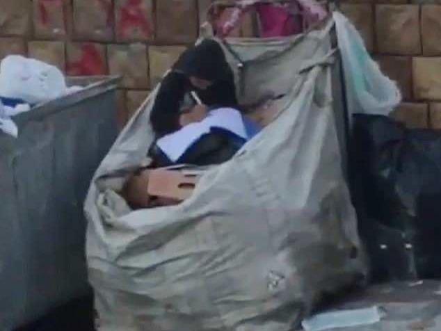 Be gai ti nan ngoi hoc tren bai rac khien nhieu nguoi xuc dong hinh anh