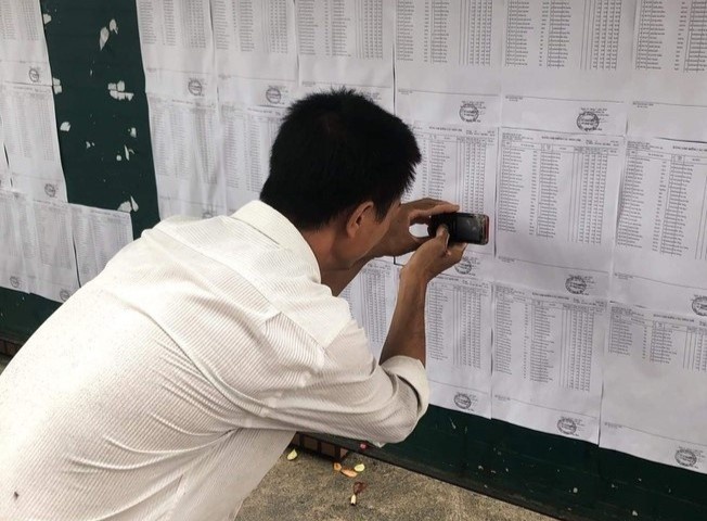 Nguoi cha chup ket qua thi cho con bang chiec dien thoai cu hinh anh