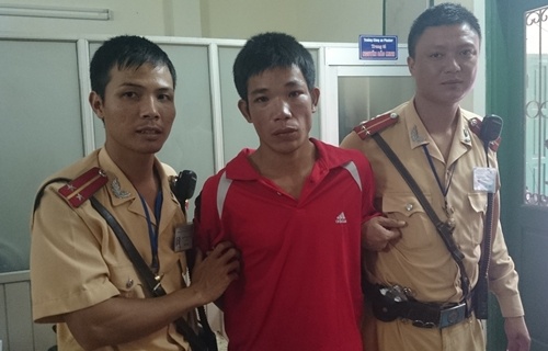 Phạm Văn Dương (áo đỏ) tại cơ quan công an.