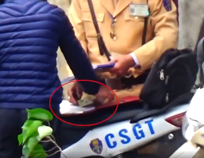 Nguoi dan dua tien cho CSGT co pham toi dua hoi lo? hinh anh