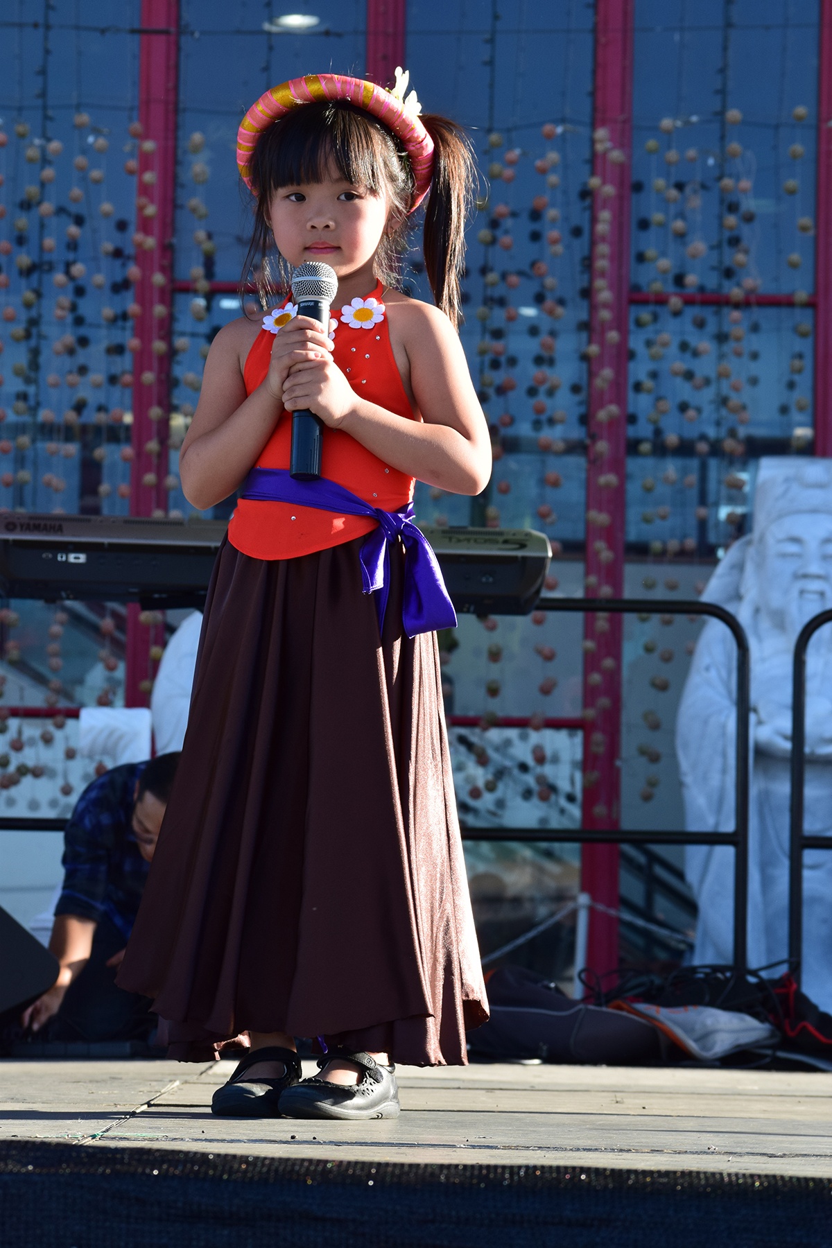 Bé gái với dải yếm đào thể hiện tiết mục đơn ca.