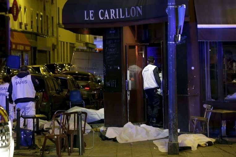 Thi thể nạn nhân được phủ kín bên ngoài nhà hàng ở Paris. Ít nhất 4 nhân viên an ninh thiệt mạng trong vụ đánh bom liều chết. Ảnh: Reuters