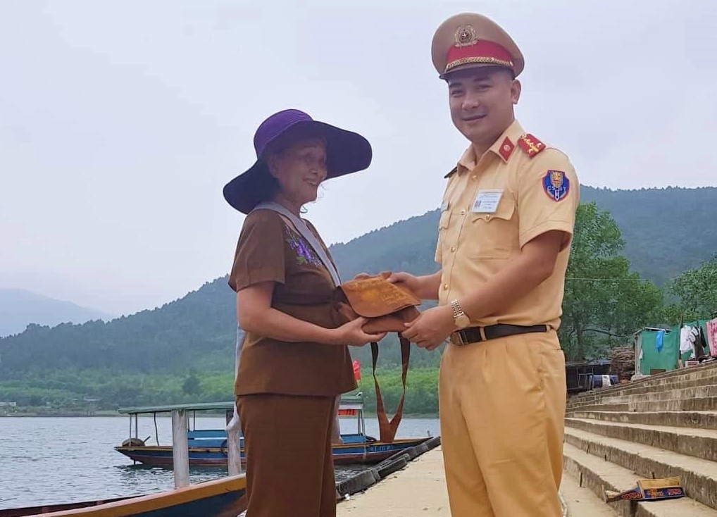 Dai uy CSGT tra lai tui tien cho nguoi danh roi khi di le chua hinh anh