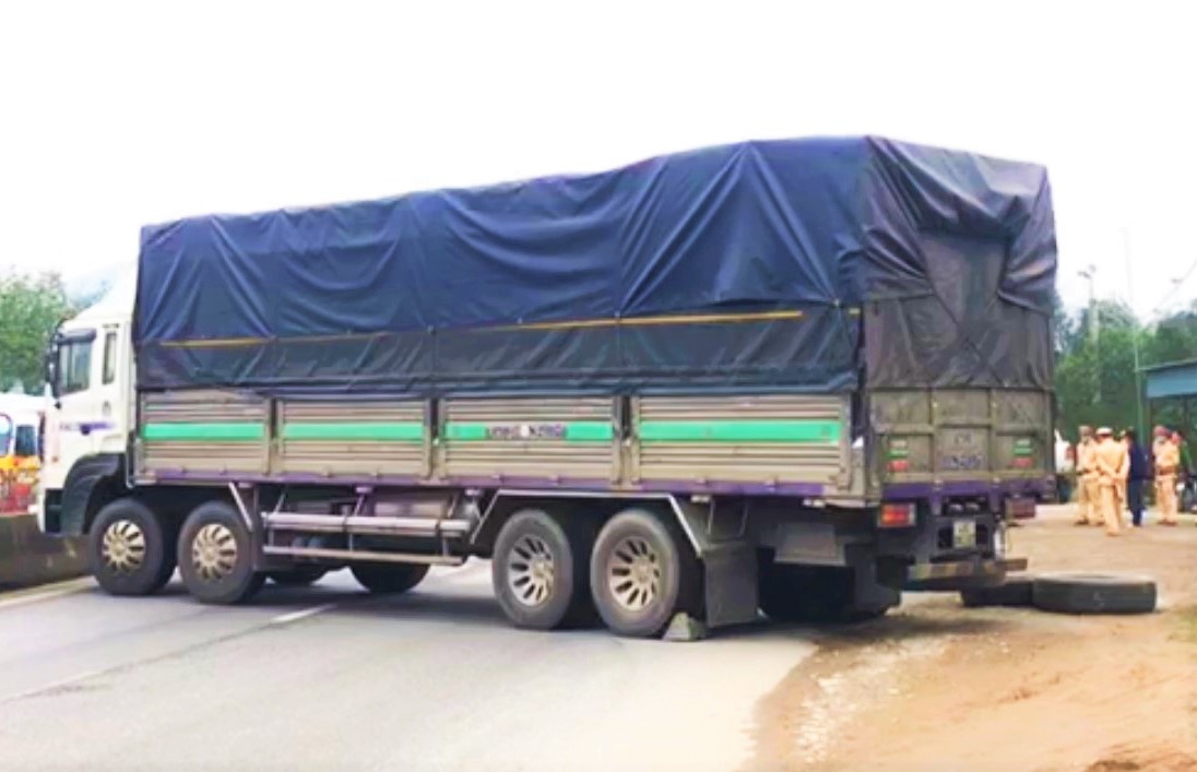 Lai xe chan quoc lo khi bi canh sat lap bien ban hinh anh