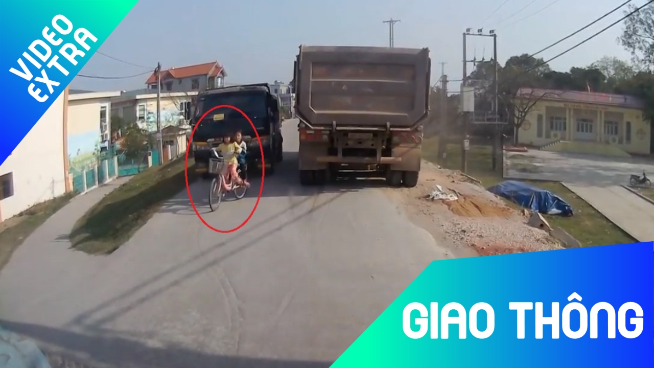 Thot tim 2 be gai di xe dap bi kep giua 2 xe tai hinh anh