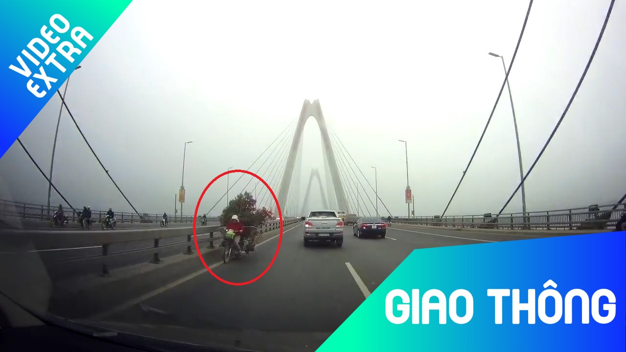 Xe may cho cay canh chay nguoc chieu kieu tren cau Nhat Tan hinh anh