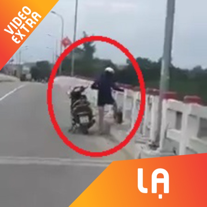 Nguoi phu nu dung xe, vut 4 tui rac xuong cau gay buc xuc hinh anh