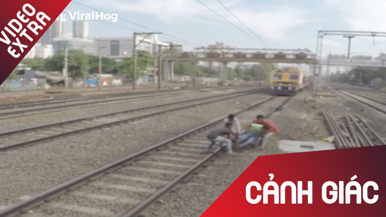 Nhom thanh nien giai cuu nguoi ban ket chan duoi duong ray hinh anh