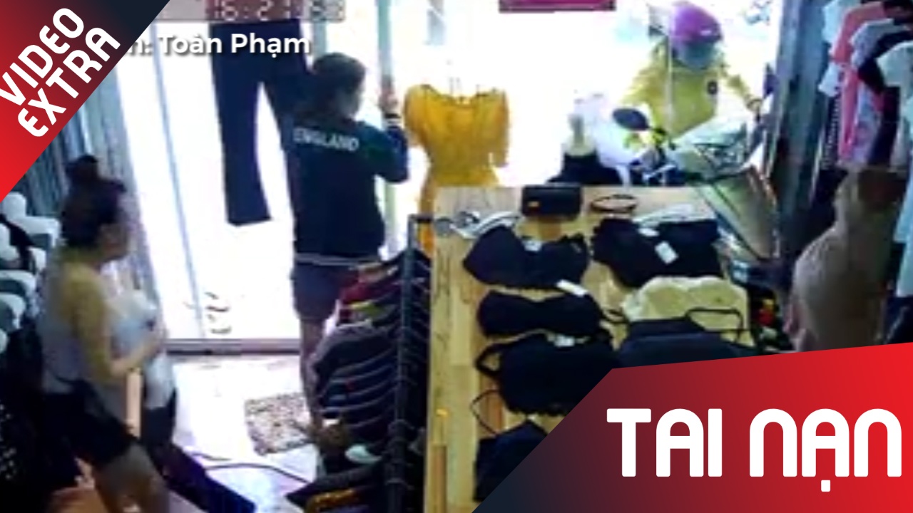 Co gai chay xe may bat ngo dam thang vao cua hang quan ao hinh anh