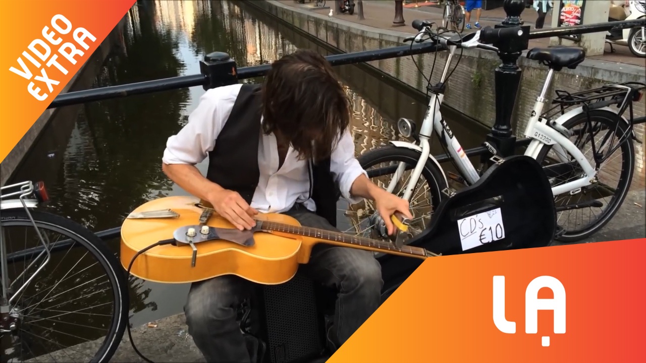 Dung binh ruou choi guitar, nguoi dan ong kiem tien tren pho hinh anh