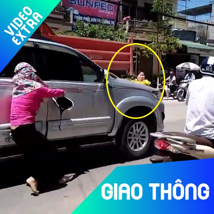 Nguoi phu nu niu cua xe, le theo oto tren pho hinh anh