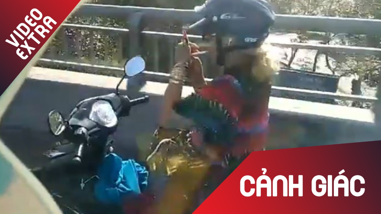 Nguoi phu nu buong hai tay khi chay xe de hut thuoc hinh anh