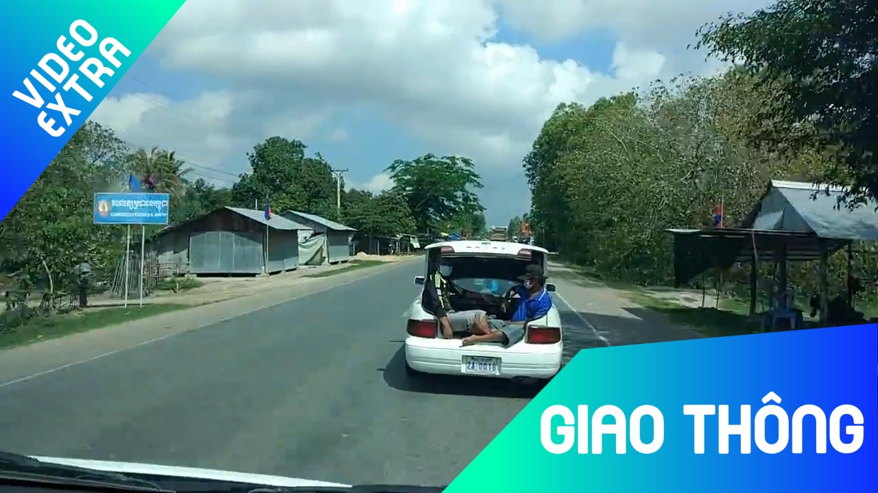 Hai nguoi dan ong ngoi cop xe oto luu thong tren duong o Campuchia hinh anh