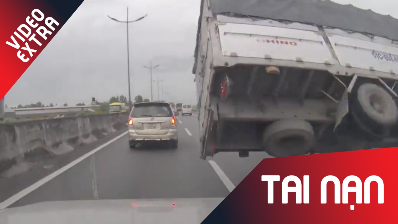 Xe tai no lop, lat ngang tren cao toc Trung Luong truoc mui oto con hinh anh