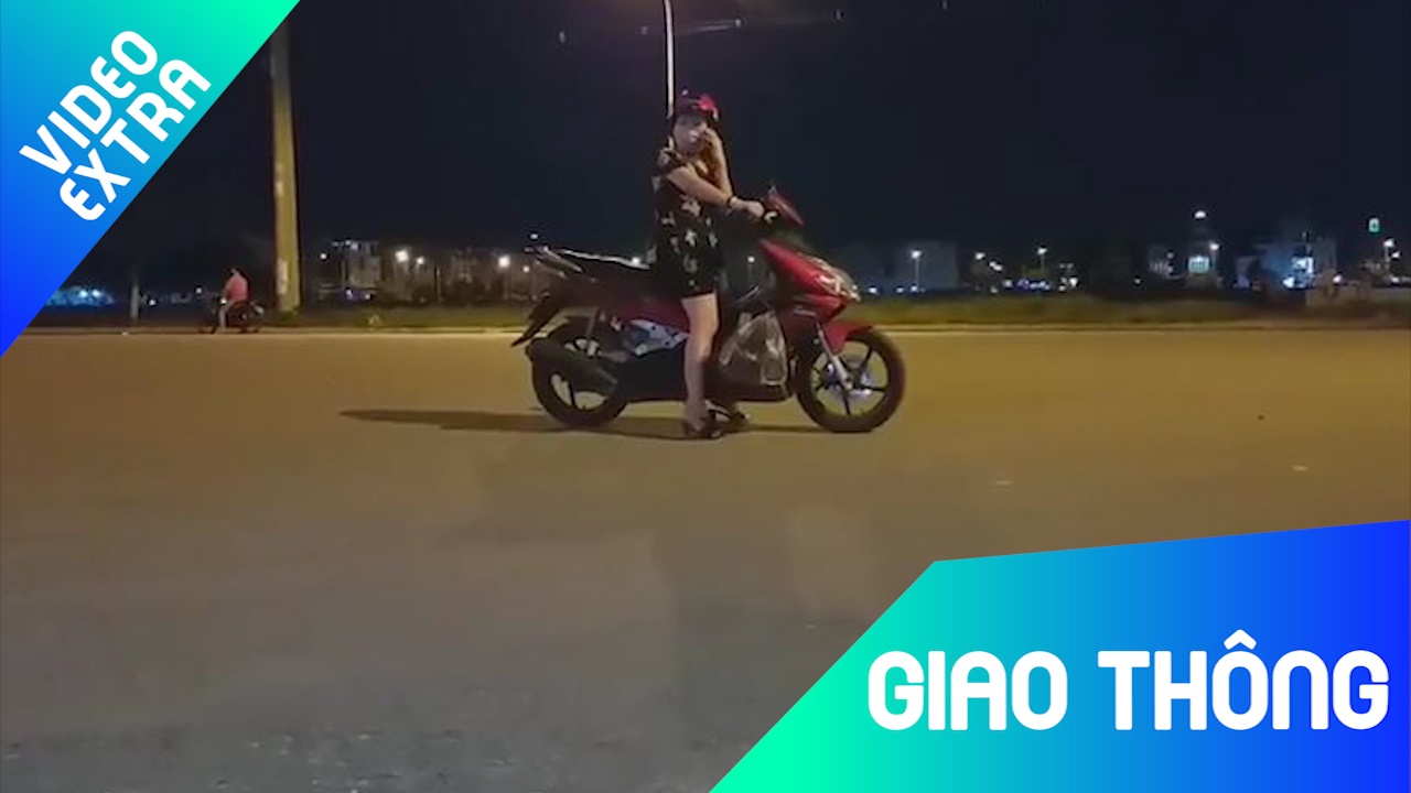 Nguoi phu nu vo tu dung xe may giua duong dong xe qua lai hinh anh