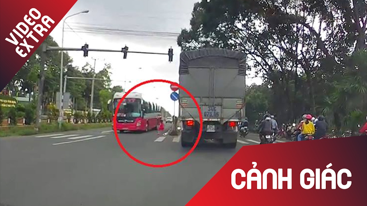 Be gai bat ngo lao thang qua duong quoc lo truoc dau xe khach hinh anh